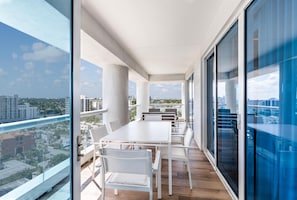 Ein moderner Balkon mit Blick auf die Stadt, mit weißer Möbel und großen Fenstern.