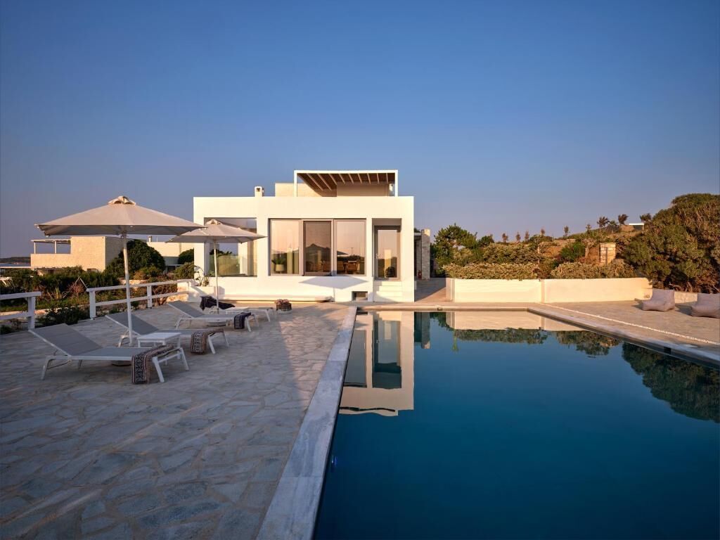 Une villa moderne dotée d’une piscine, d’un espace extérieur aménagé et offrant une vue sur le paysage environnant.