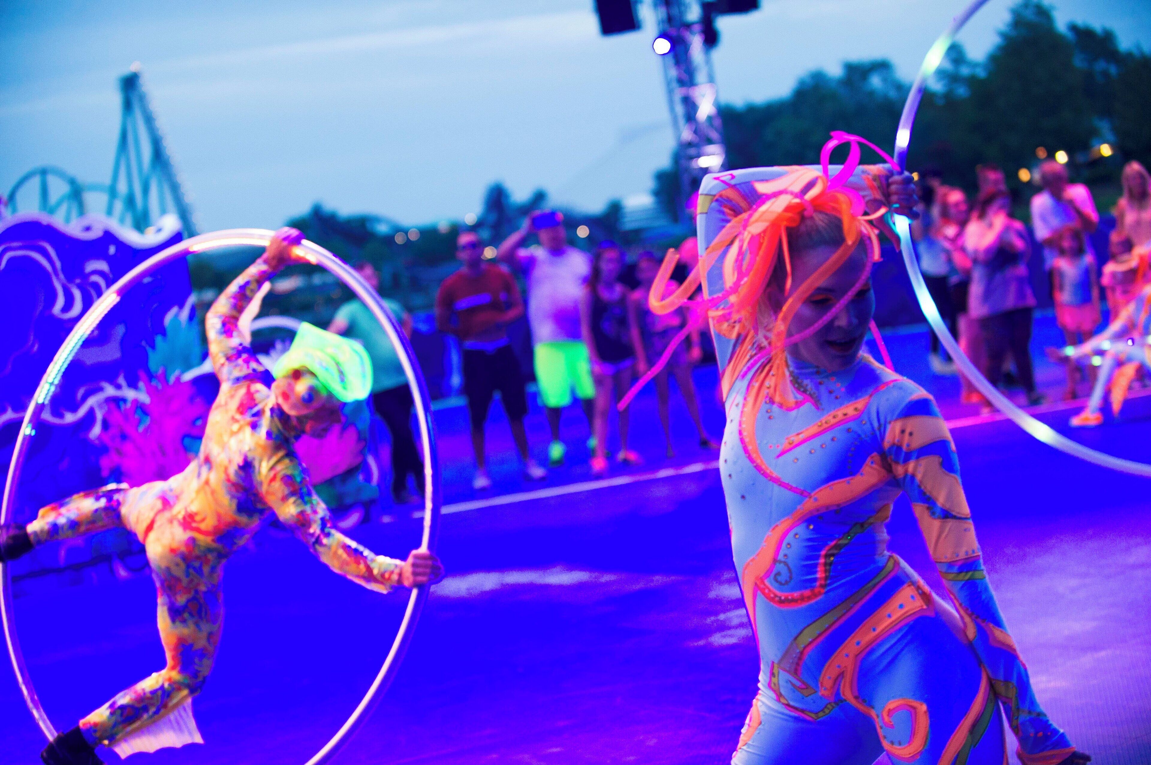 A person in a colorful costume with a bow, performing with a hoop.