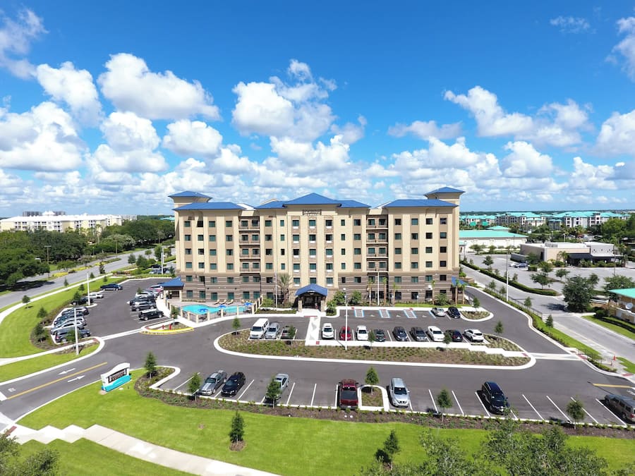 A hotel with a central courtyard, multiple parking levels, and a swimming pool.