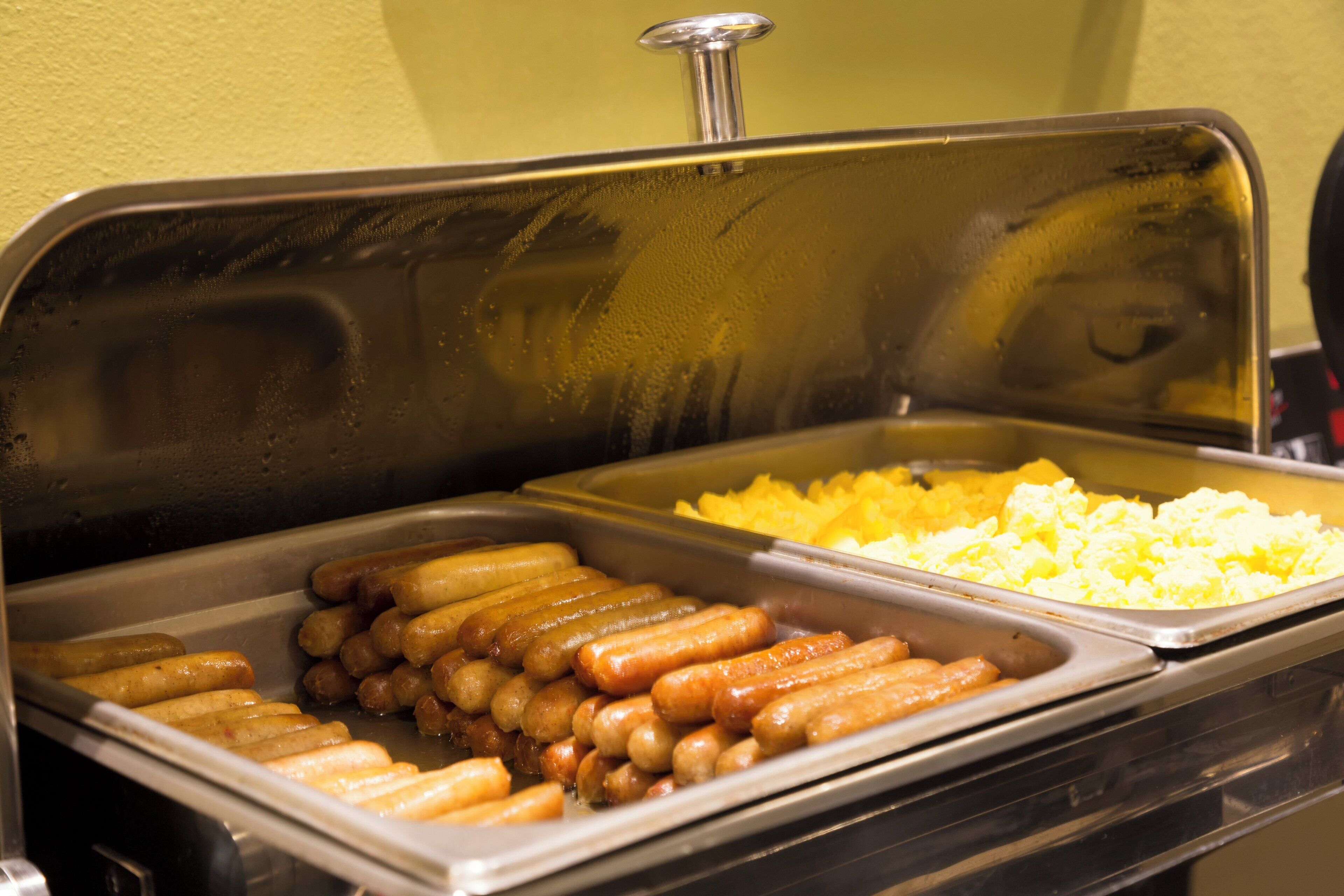 A buffet with hot dogs and potatoes.