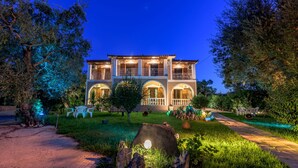 A two-story building with a balcony, surrounded by greenery and a well-maintained garden. - Pansion Mary Studios (Zakynthos)