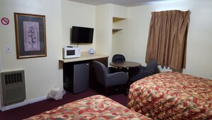 A hotel room with two beds, a desk with a TV, a microwave, and a chair. - Colonial West Motel (Batavia)