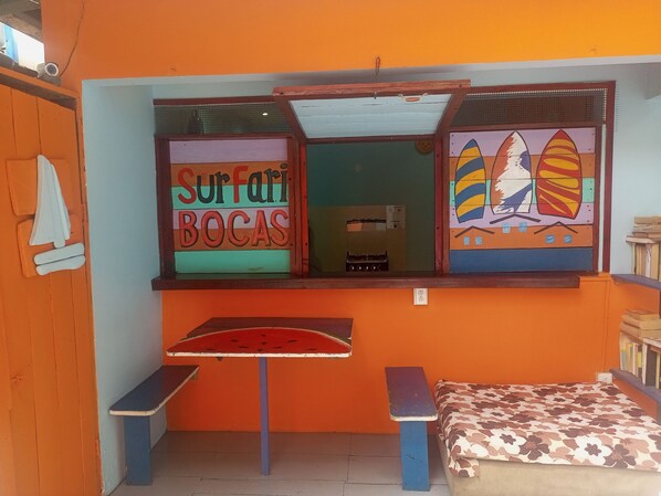 A room with a bed, a small table, and a bench. - Surfari Bocas (Bocas del Toro)