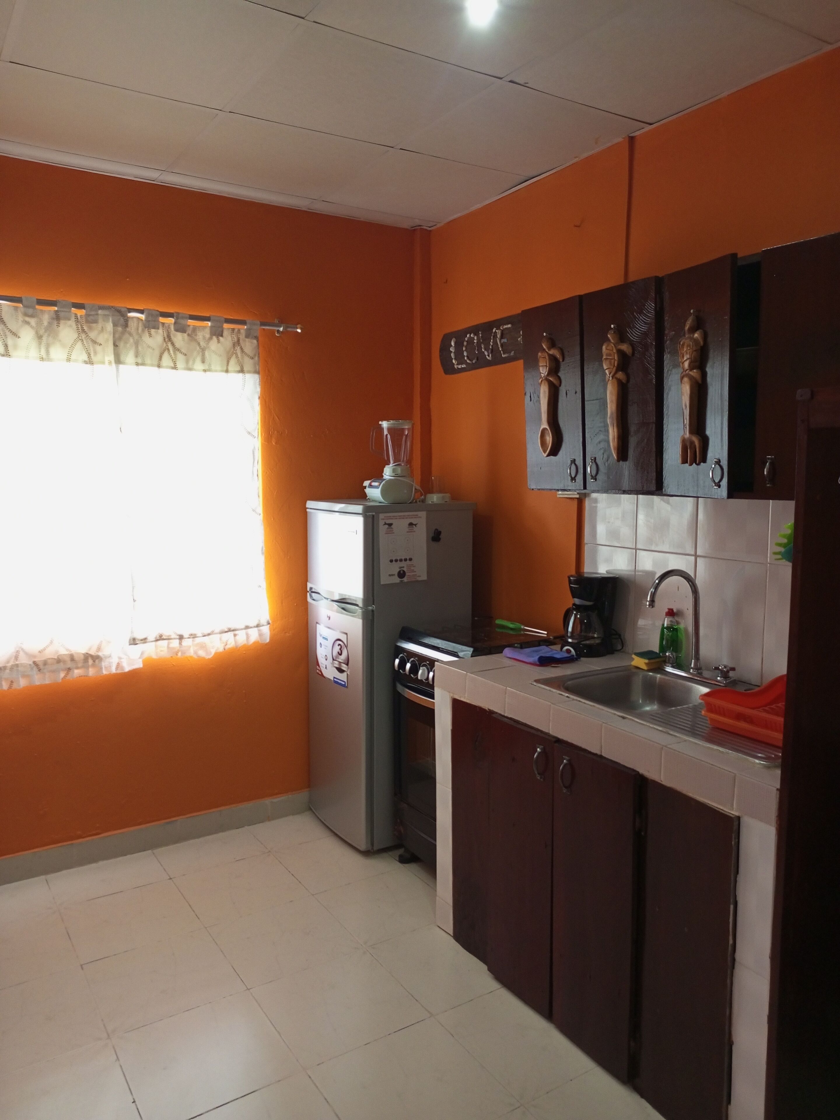 A compact kitchen with a refrigerator, stove, and sink.