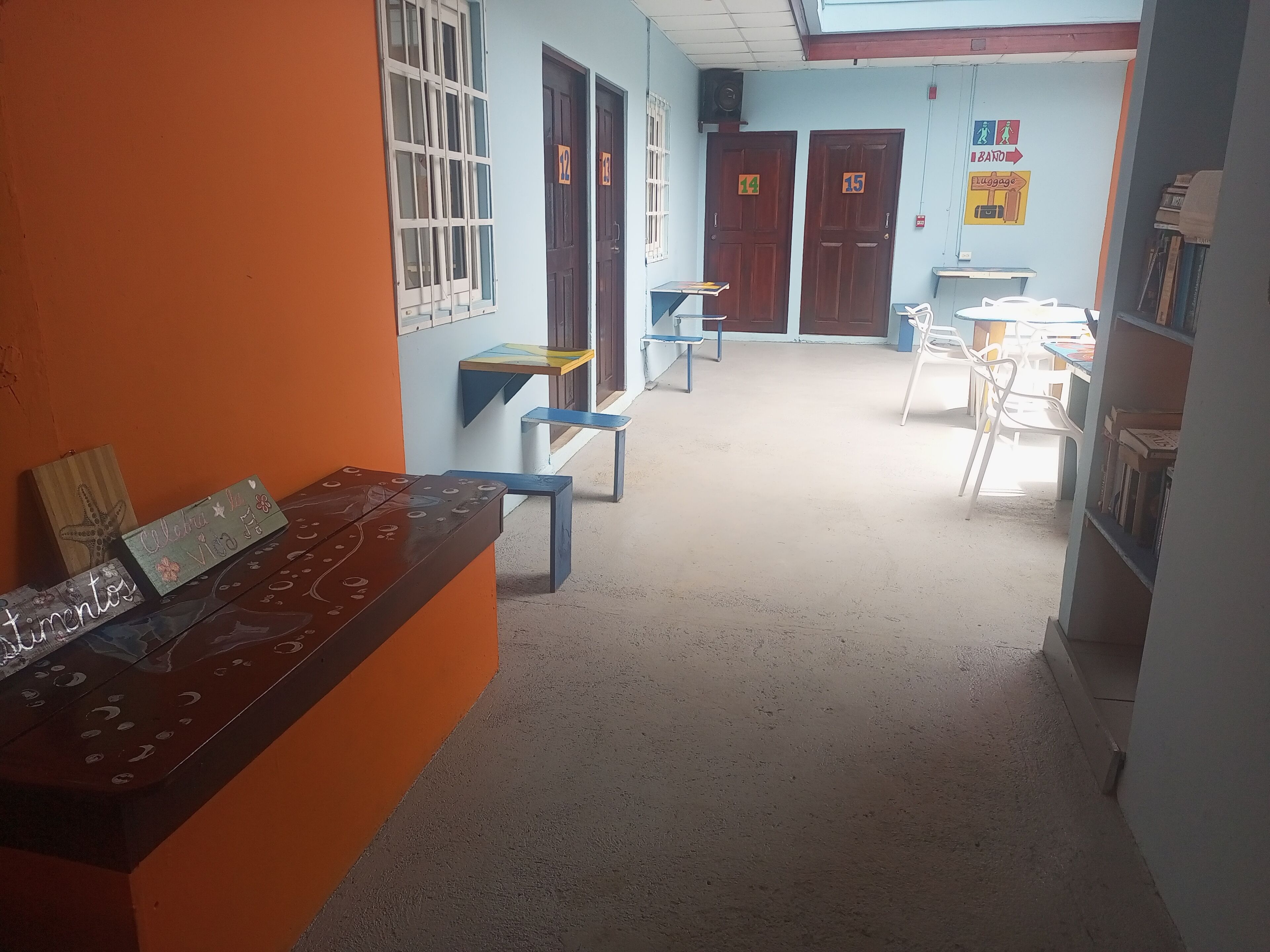 A classroom with numbered doors, a bulletin board, and a desk with a nameplate.