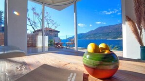 Una habitación moderna con ventanas amplias, una mesa de madera y un cuenco de limones.