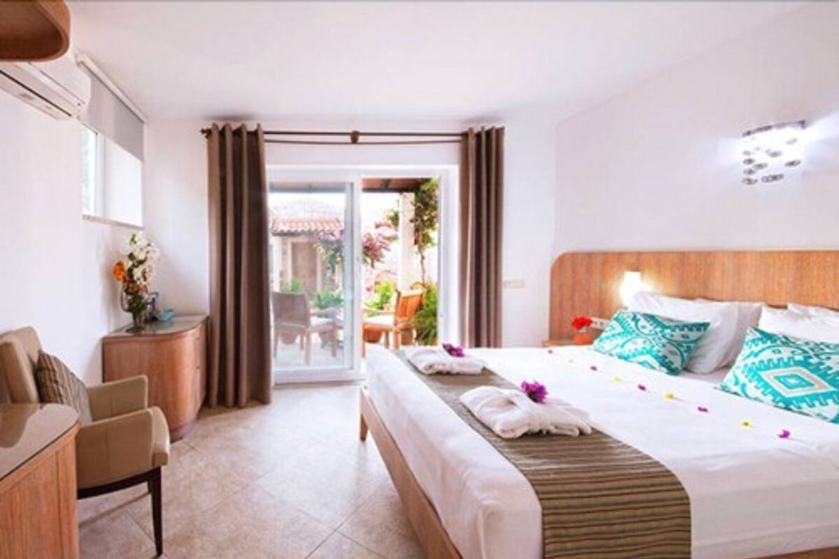 Una camera d'albergo con un letto, una scrivania e vista sull'esterno.