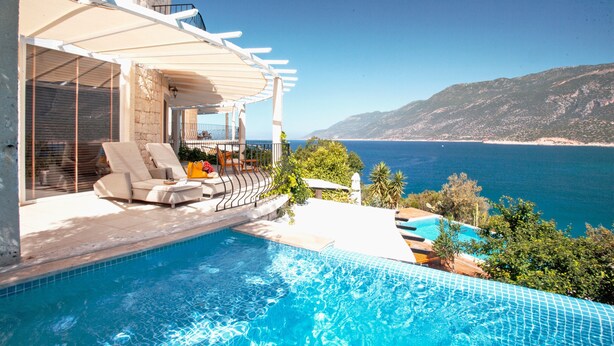 Una piscina con vista al mar y a las montañas.