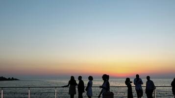 Une vue sur le coucher de soleil depuis un balcon donnant sur la mer.