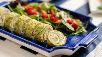 A blue plate with rolled appetizers and a side salad.