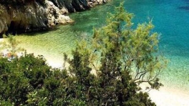 A coastal beach with clear turquoise water and a sandy shore. - Hotel Nostos (Ithaki)