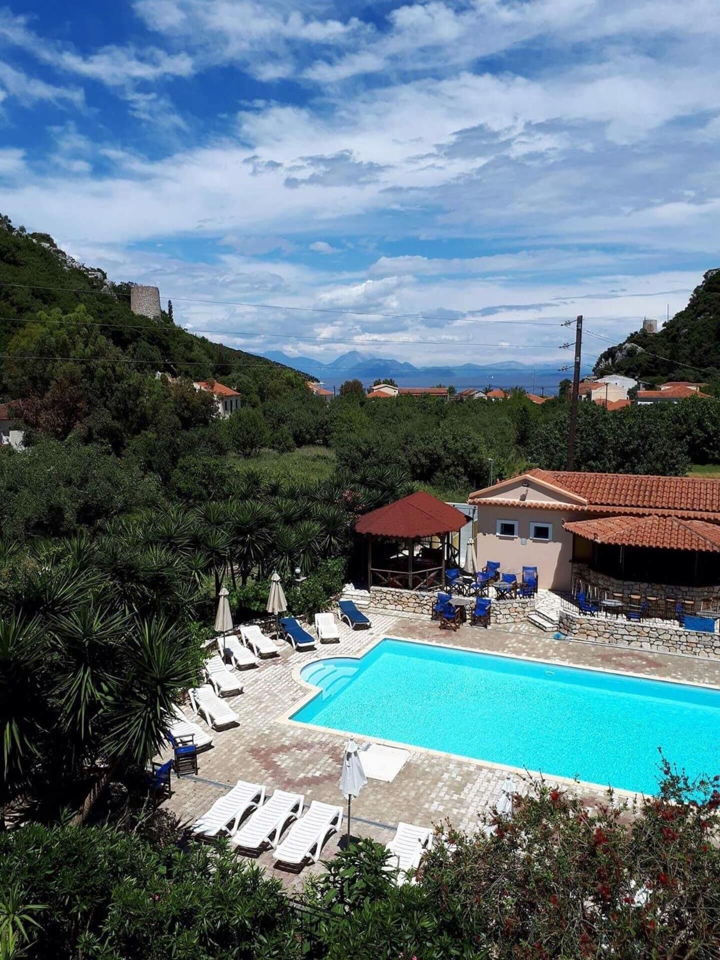 Una piscina al aire libre de temporada, sillones reclinables de piscina