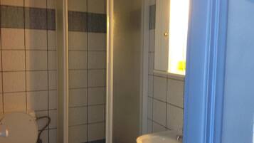 A bathroom with a toilet, a sink, and a shower stall.