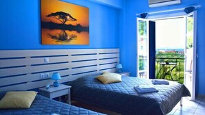 A bedroom with two beds, a nightstand, a painting of a tree, and a balcony with a view. - Hotel Nostos (Ithaki)