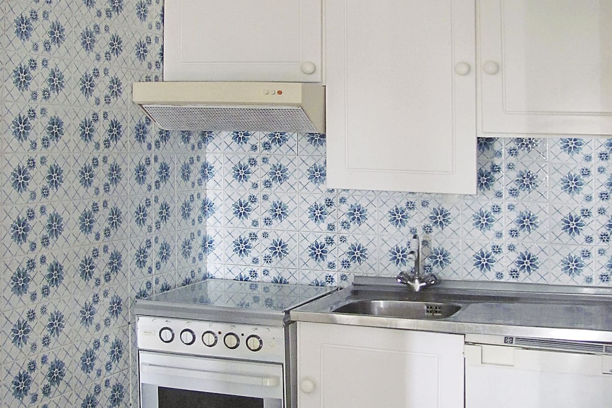 Frigorífico grande, placa de cocina y utensilios de cocina