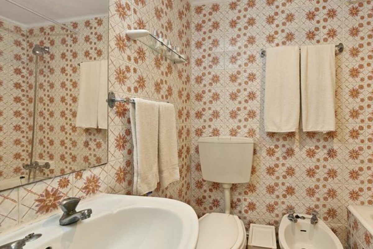 Un baño con lavamanos, inodoro y ducha.