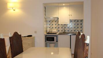Full-sized fridge, stovetop, cookware/dishes/utensils