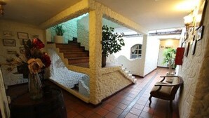 A spacious interior with a central staircase, a seating area, and a decorative plant. - Quito Antiguo (Quito)