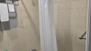 Un baño con bañera, cortina de ducha y retrete.