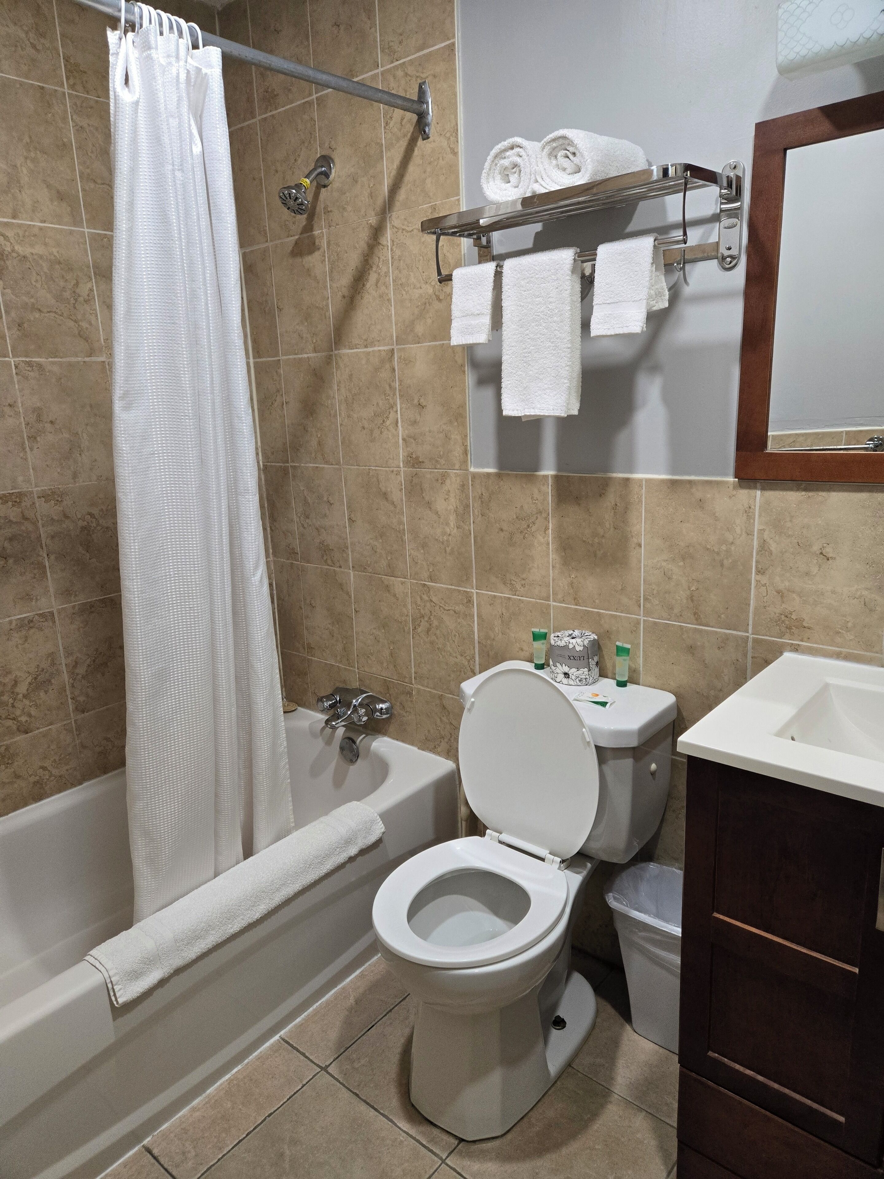 Un baño con bañera, inodoro y lavamanos.