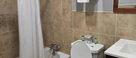 Un baño con bañera, inodoro y lavamanos.