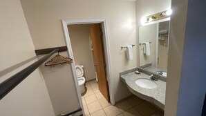 A bathroom with a toilet, sink, and mirror. - Regal Motel in Las Vegas, New Mexico (Las Vegas)