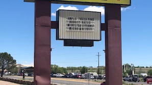 A sign for Regal Inn with a clear view of the surrounding area including a road and parked vehicles. - Regal Motel in Las Vegas, New Mexico (Las Vegas)