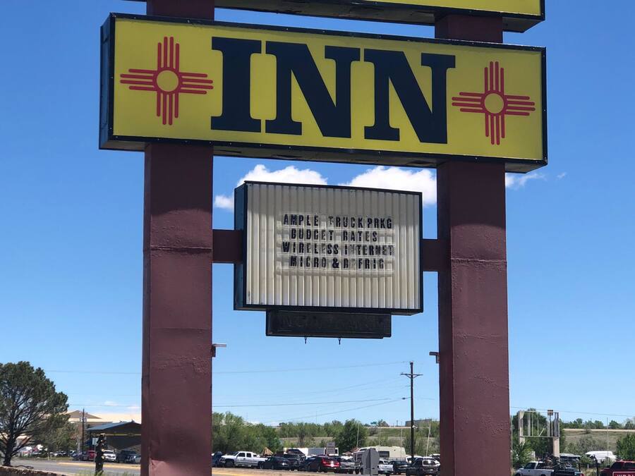 A sign for Regal Inn with a clear view of the surrounding area including a road and parked vehicles.