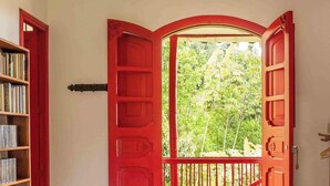 Una puerta roja con vistas a zonas verdes.
