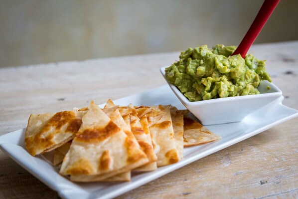 Un plato de quesadillas y un tazón de guacamole.