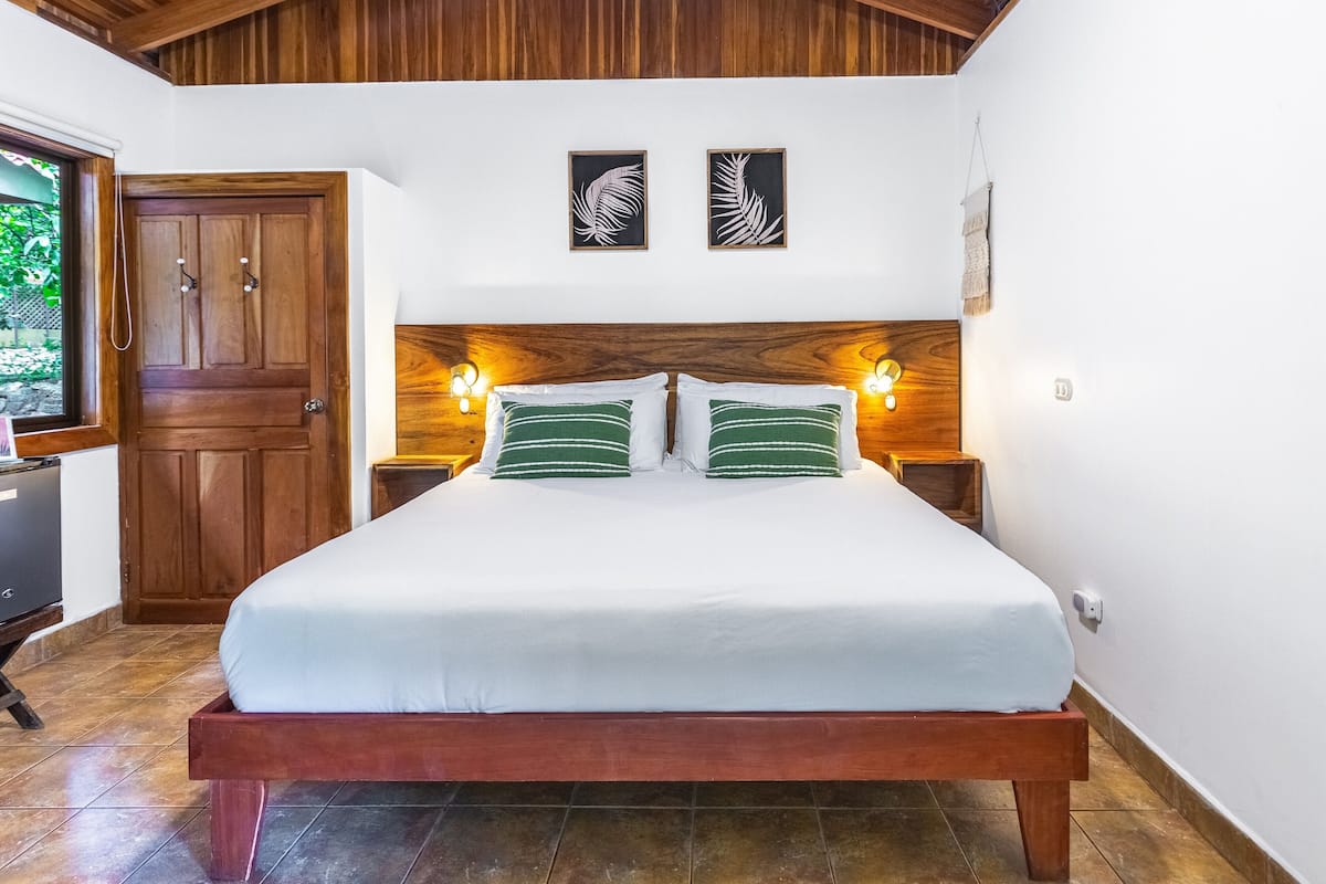 Ein Schlafzimmer mit einem hölzernen Bett, zwei Nachttischlampen und einer Holztür.