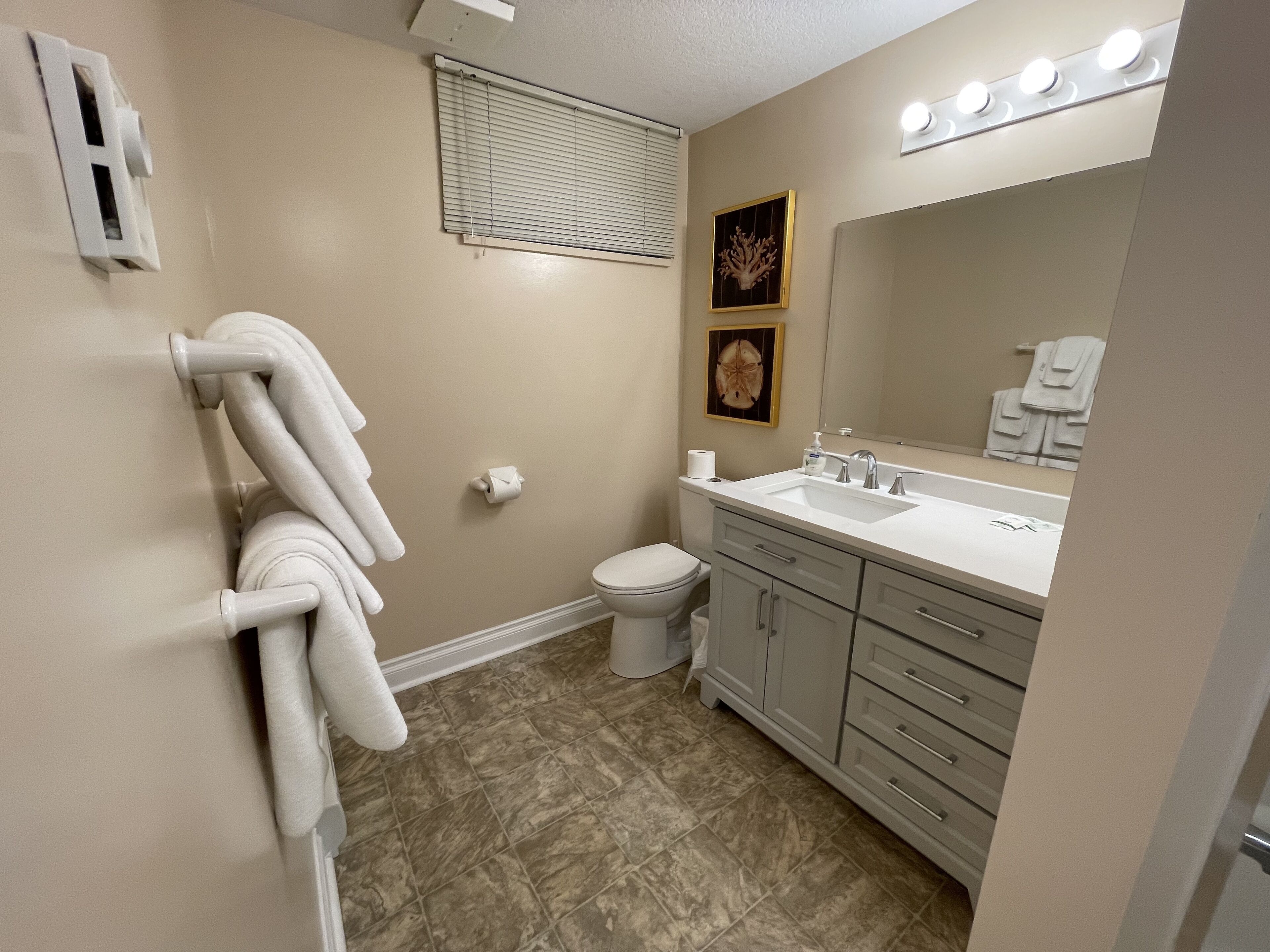 Un baño con inodoro, lavamanos y barra para toallas.