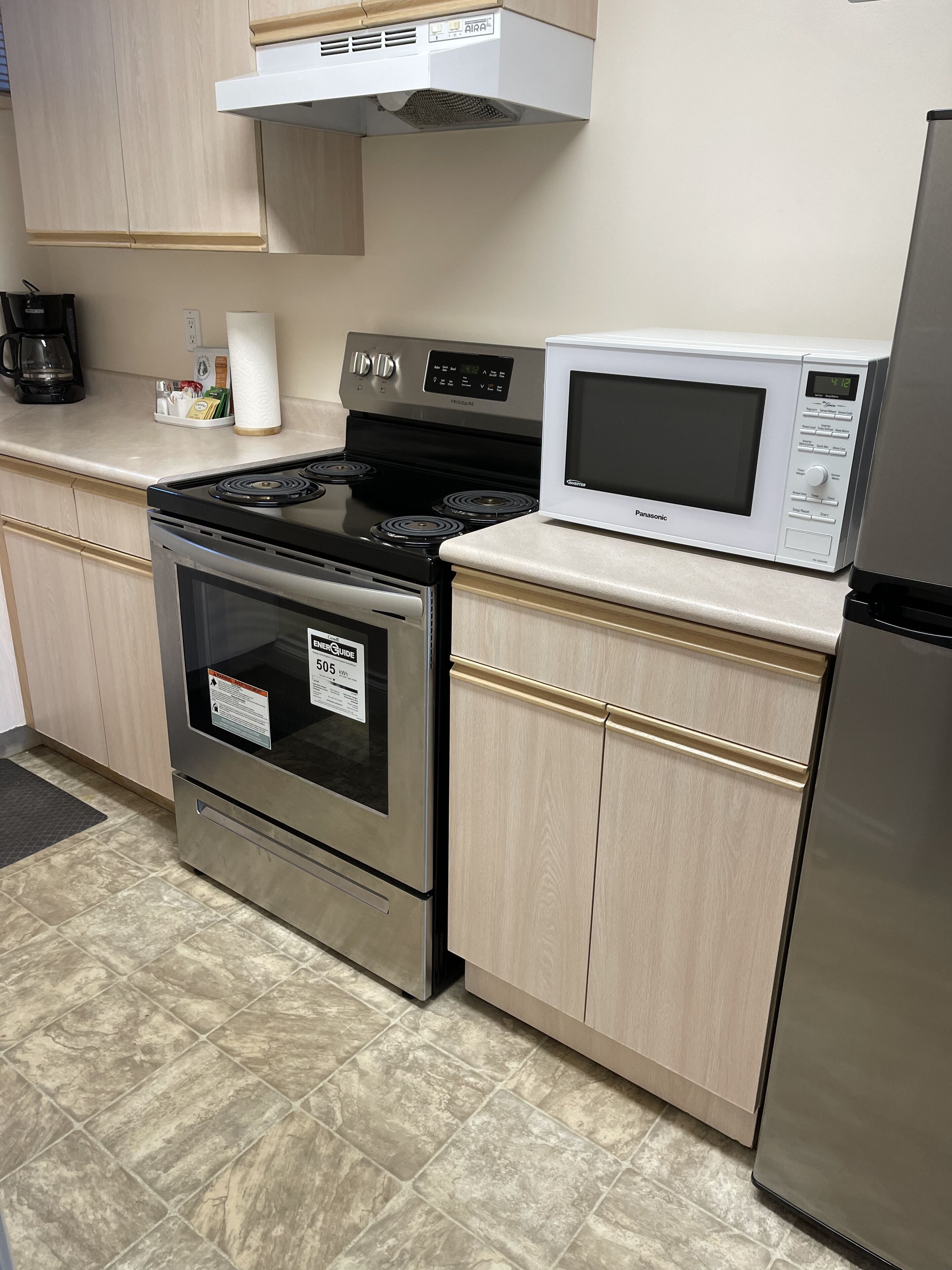 A kitchen with a stainless steel stove, a microwave, and a refrigerator.