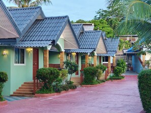 A row of houses with pitched roofs, a central pathway, and surrounding greenery. - Phaithong Sotel Resort (Chalong)