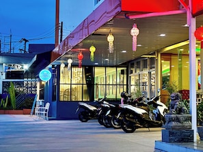 A building with a sign for 'FRUITTRIO' and a row of parked motorcycles outside. - Phaithong Sotel Resort (Chalong)