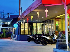 Un edificio con un cartello che riporta 'FRUITTRIO' e una fila di motociclette parcheggiate davanti.