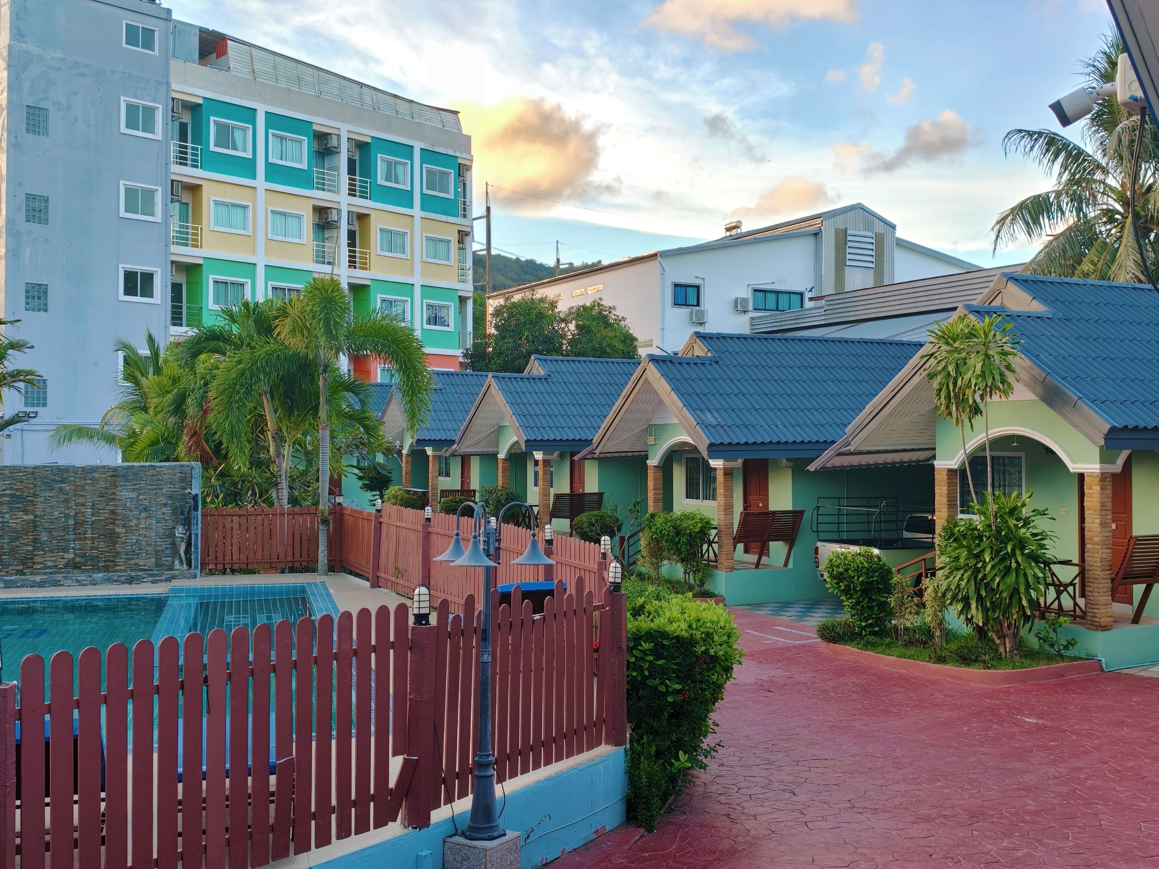 A residential area with colorful houses, a swimming pool, and a red pathway.
