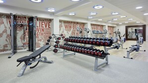 A gym with weightlifting equipment, benches, and dumbbells. - Hilton Garden Inn Sunderland (Sunderland)