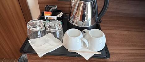 A tray with a kettle, cups, and jars, likely for breakfast.