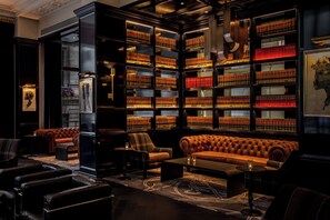 A library with leather sofas, bookshelves, and a patterned carpet. - Kimpton Gray Hotel by IHG (Chicago)