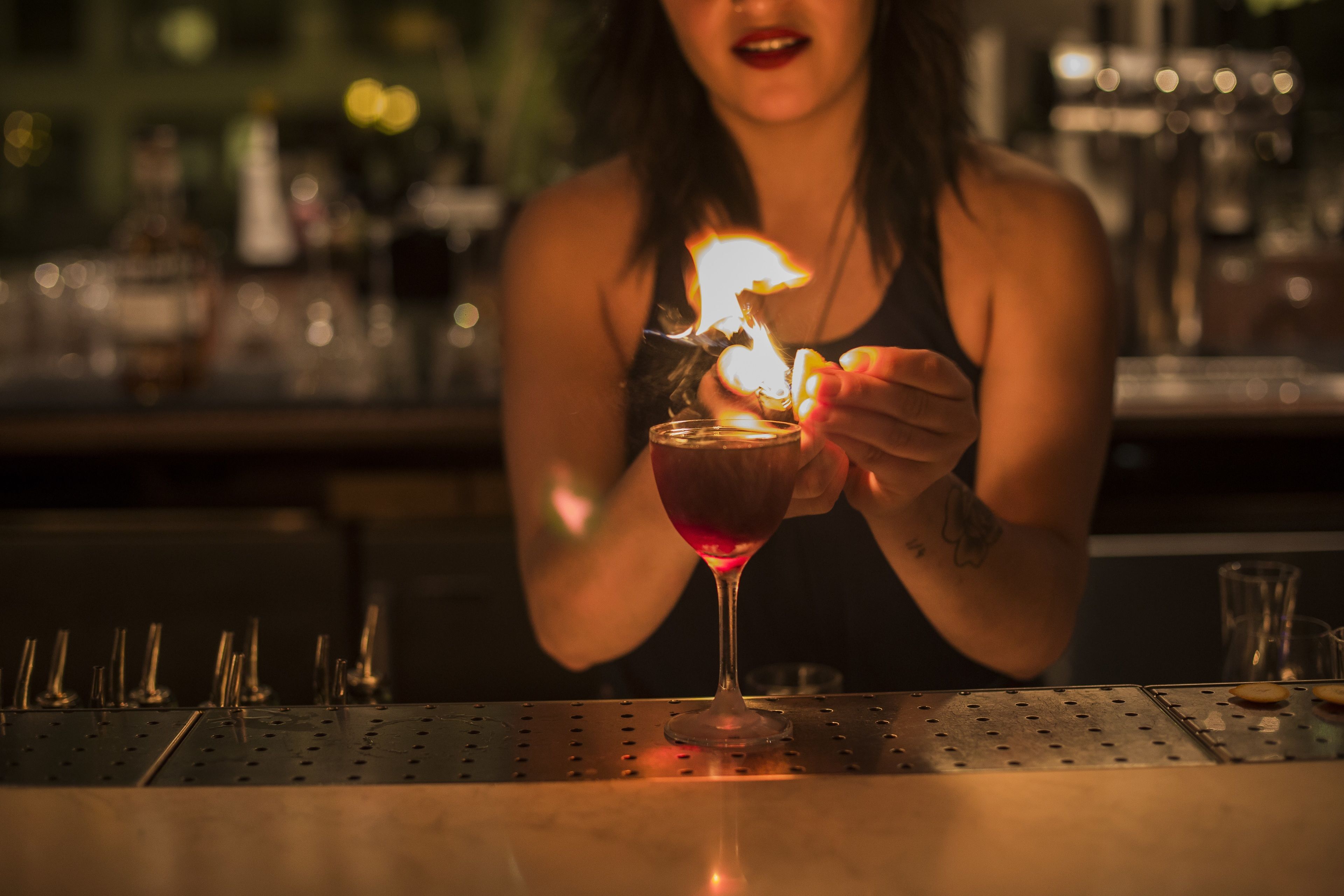 A person holding a lit candle in a glass.