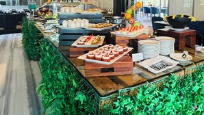 A buffet area with various food items, a bar, and seating arrangements. - Signature 1 Hotel Tecom (Dubai)