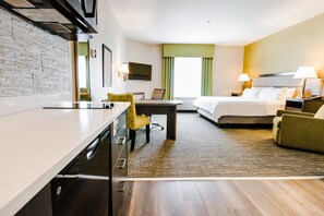 Quarto de hotel com cama, escrivaninha, cadeira, televisão e janela com cortinas.
