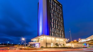 Un hôtel moderne doté d’une tour verticale imposante et d’une aile horizontale.