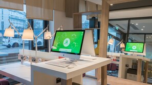 Un moderno mostrador de recepci ón de hotel con dos monitores mostrando la página web de Holiday Inn, un teclado y un ratón.