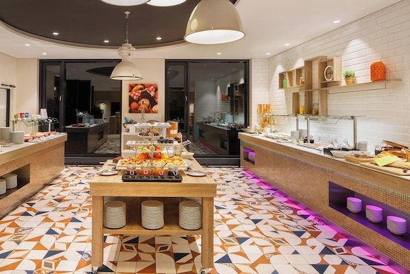 A buffet area with a variety of food items and a tiled floor.