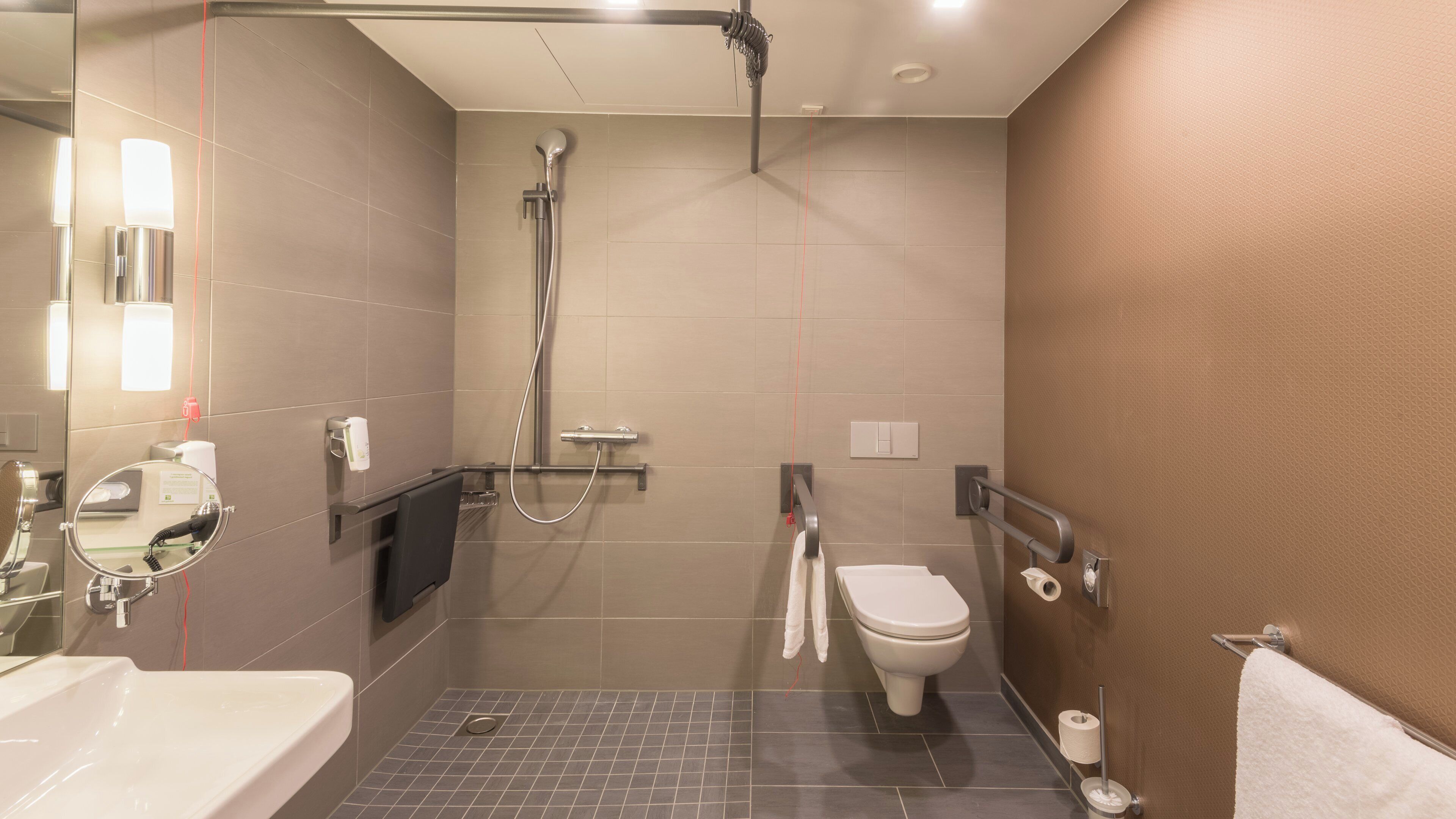 A modern bathroom with a shower, toilet, and sink.