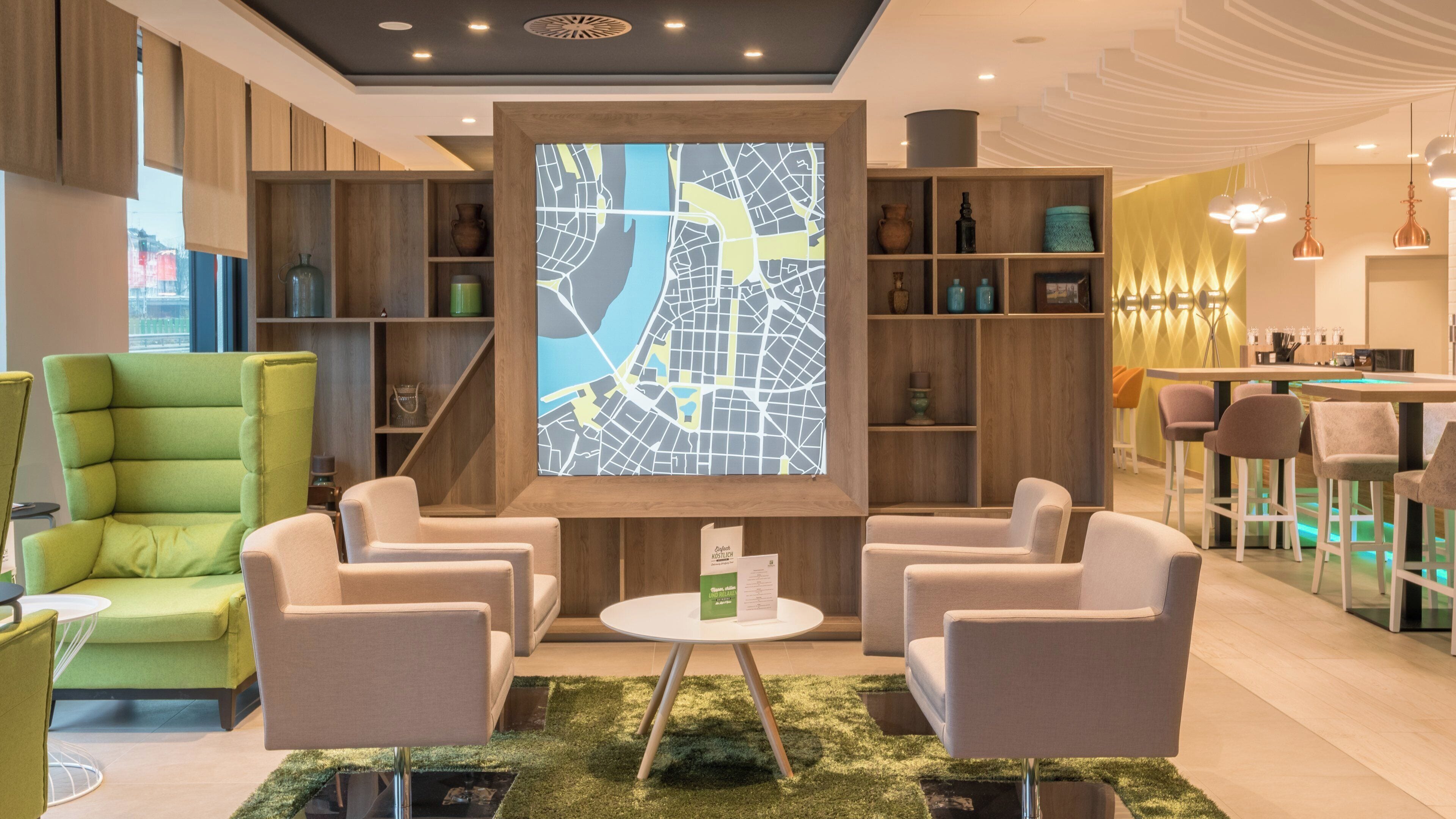 A modern lobby with a map display, seating area, and bar/lounge setup.