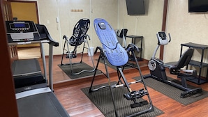 A gym with treadmills, elliptical machines, and a stationary bike. - Rose City Inn & Suites (Tyler)